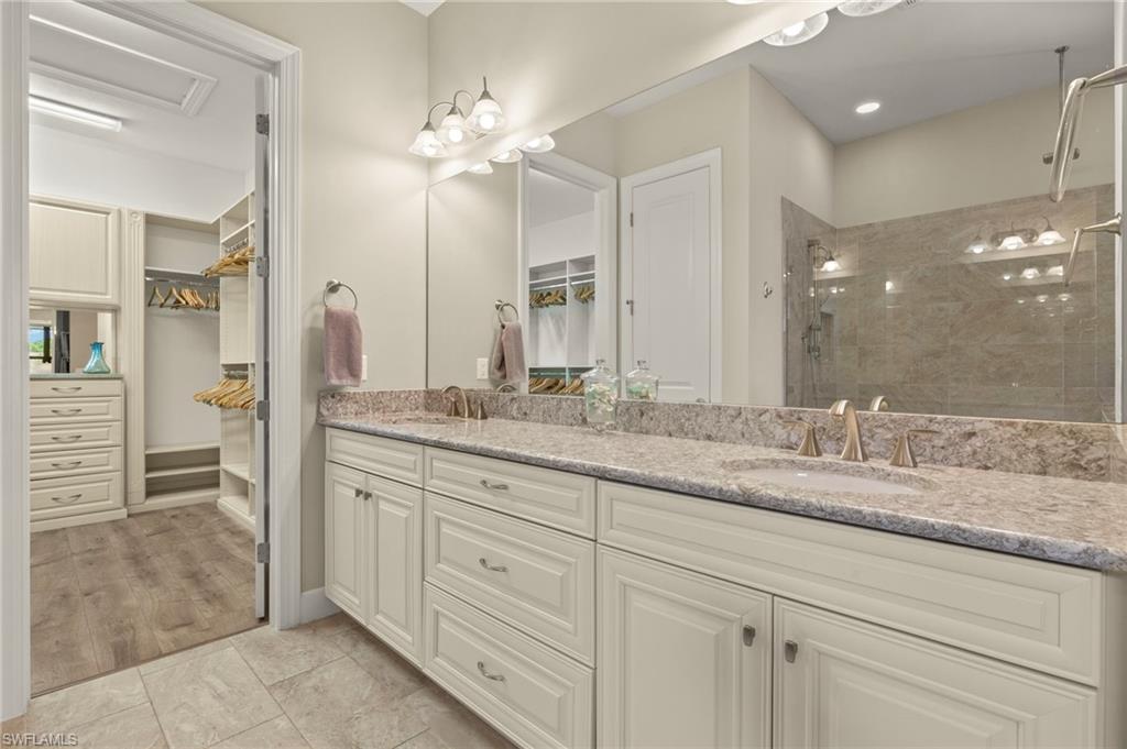 10234 Coconut Road Estero, FL 34135 - Photo 19 of 36 a bathroom with a granite countertop sink mirror and shower