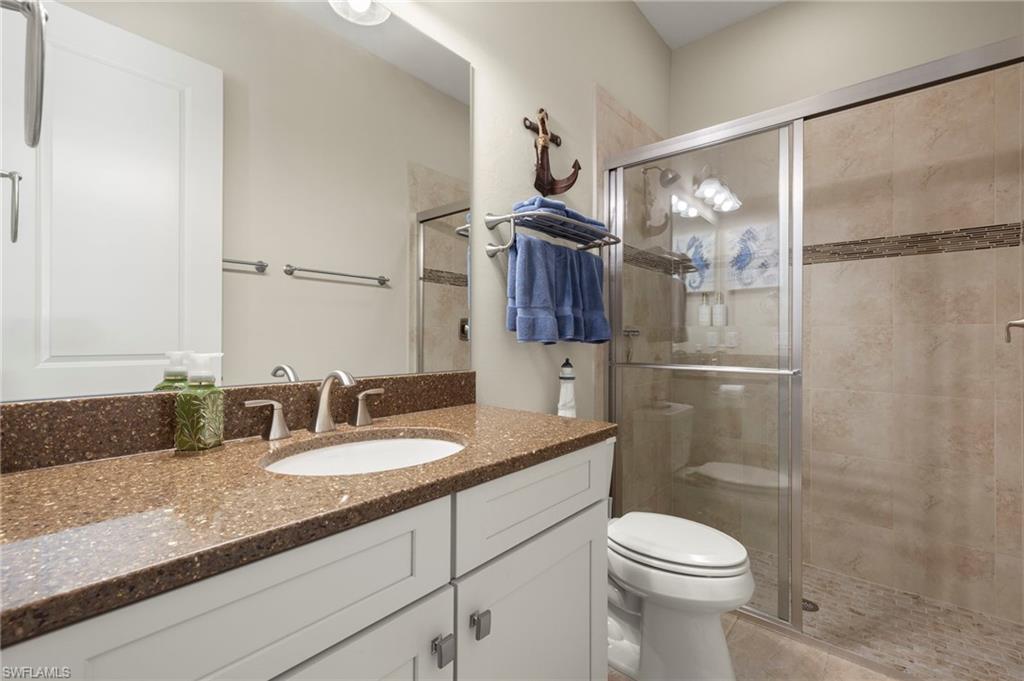 10234 Coconut Road Estero, FL 34135 - Photo 23 of 36 a bathroom with a granite countertop sink toilet and shower