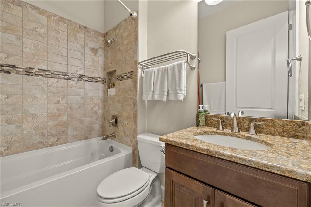 10234 Coconut Road Estero, FL 34135 - Photo 25 of 36 a bathroom with a granite countertop sink toilet and shower