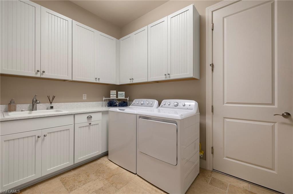 10234 Coconut Road Estero, FL 34135 - Photo 27 of 36 a utility room with cabinets washer and dryer