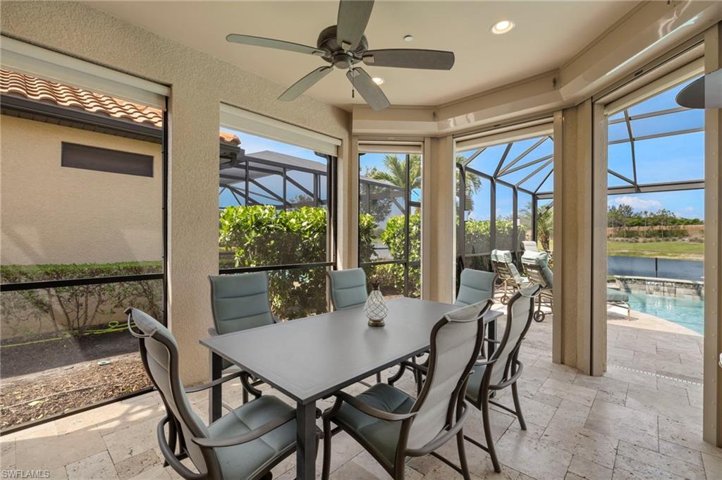 10234 Coconut Road Estero, FL 34135 - Photo 32 of 36 a view of a dining room with furniture large windows wooden floor and a chandelier