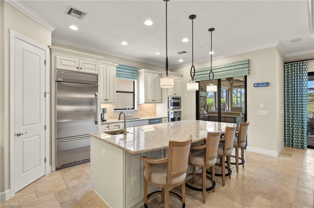 10234 Coconut Road Estero, FL 34135 - Photo 5 of 36 a kitchen with kitchen island granite countertop a table and chairs