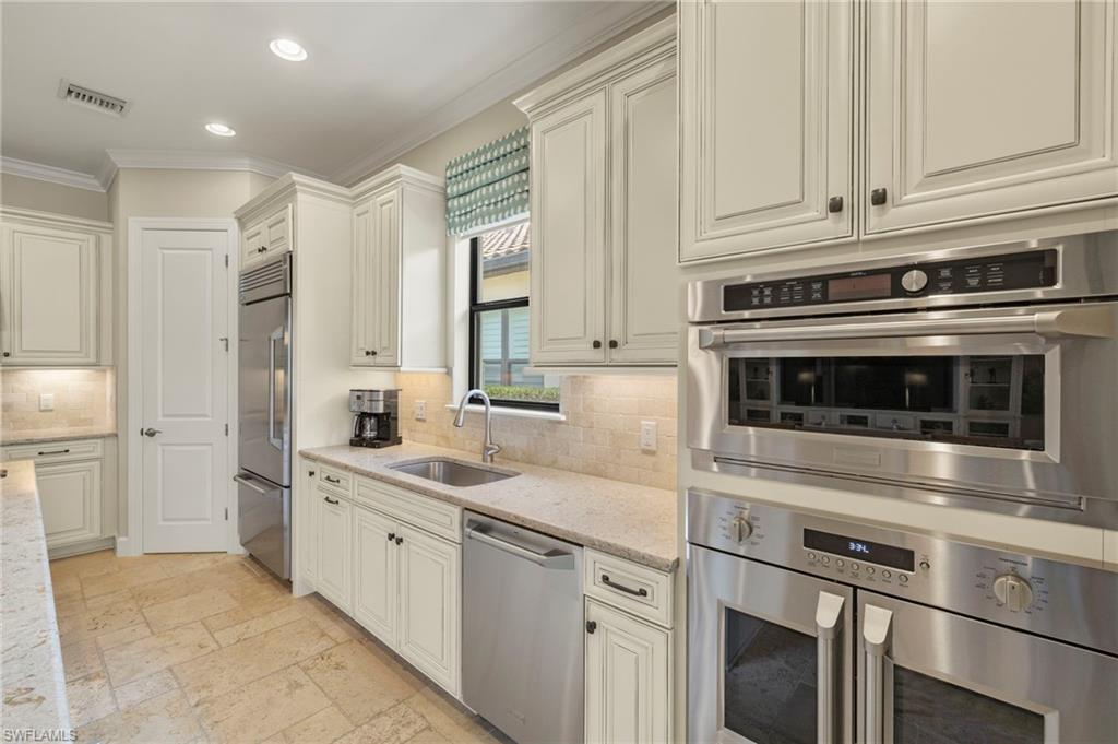 10234 Coconut Road Estero, FL 34135 - Photo 7 of 36 a kitchen with appliances a sink and cabinets