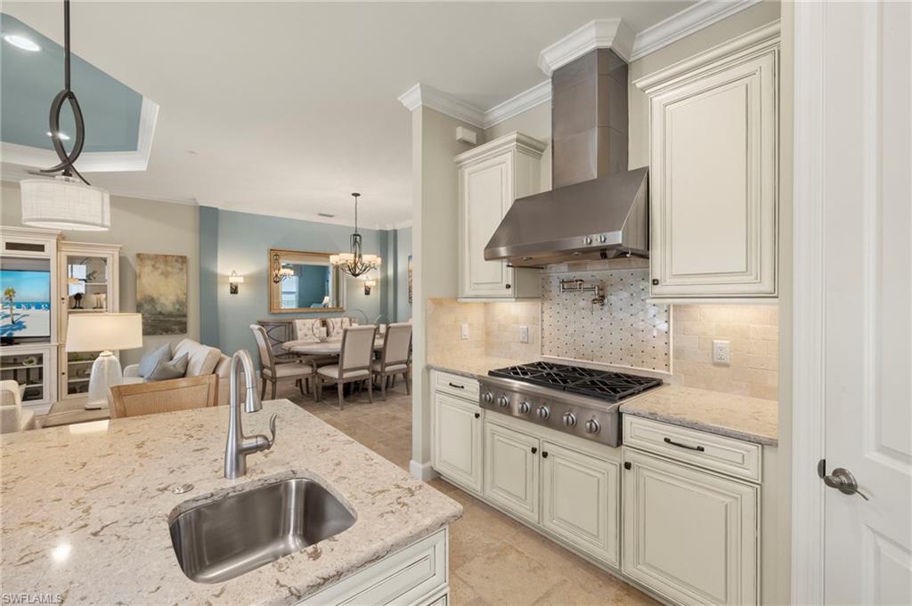 10234 Coconut Road Estero, FL 34135 - Photo 8 of 36 a kitchen with granite countertop a sink a stove and cabinets