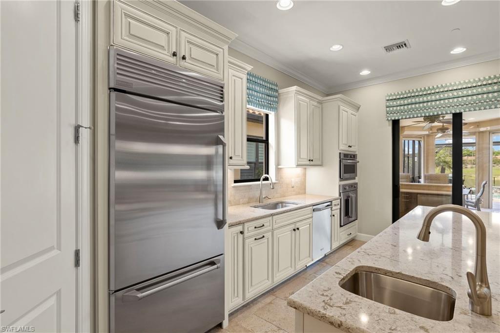 10234 Coconut Road Estero, FL 34135 - Photo 9 of 36 a kitchen with a refrigerator sink and cabinets