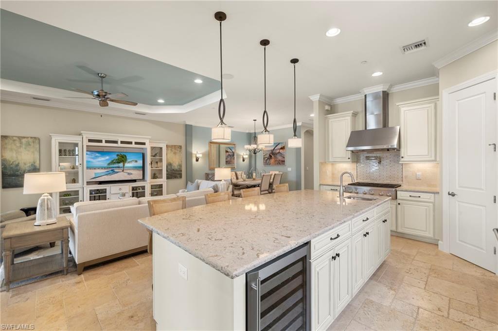10234 Coconut Road Estero, FL 34135 - Photo 10 of 36 a large kitchen with kitchen island a large counter space a sink stainless steel appliances and cabinets