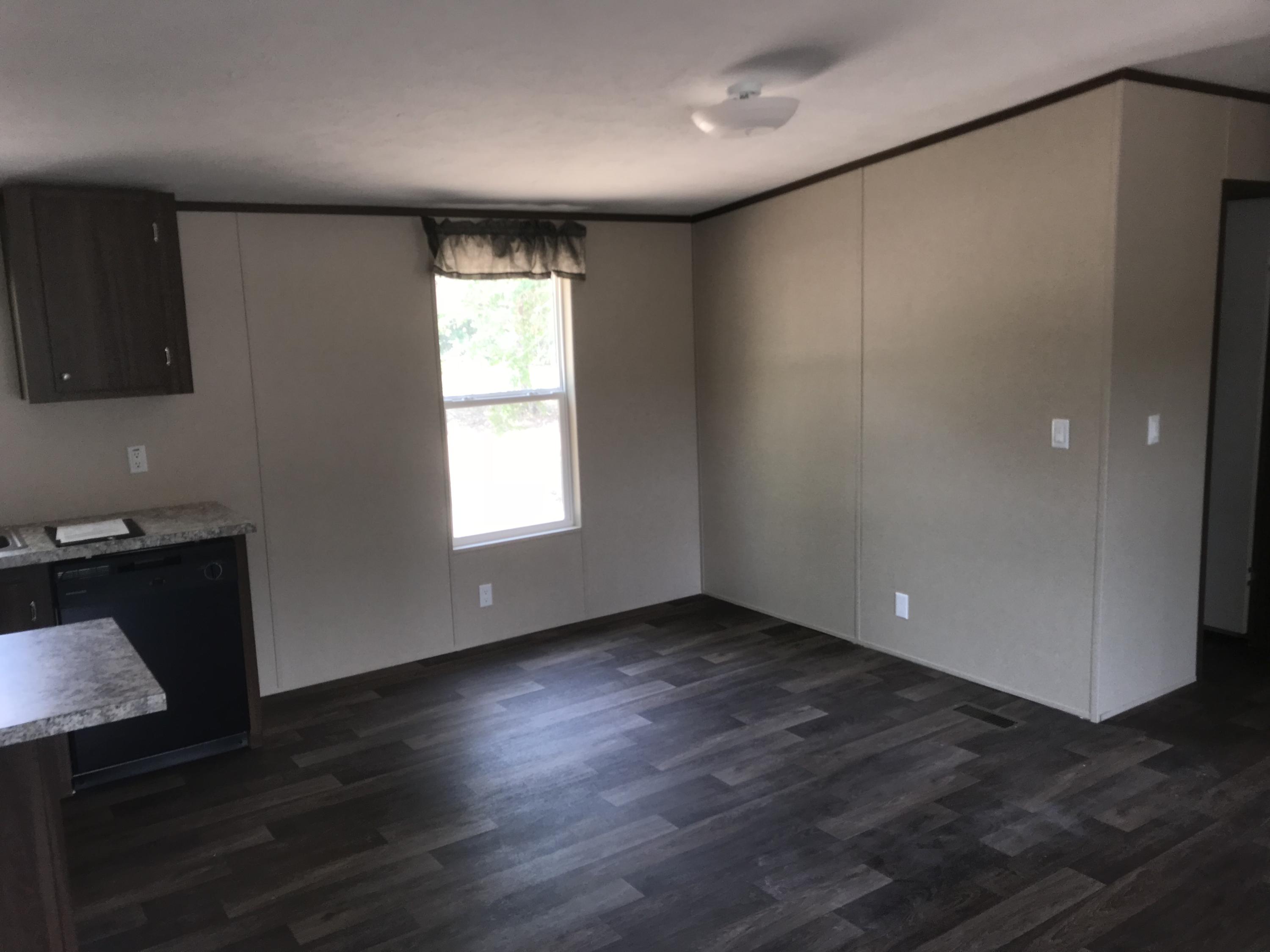 1514 Trotter Way Baker, FL 32531 - Photo 7 of 8 a view of an empty room with wooden floor and a window