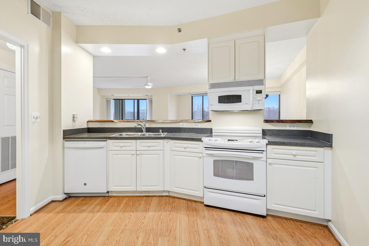 3100 North Leisure World Boulevard, Unit 603 Silver Spring, MD 20906 - Photo 12 of 49 a kitchen with granite countertop white cabinets and white appliances