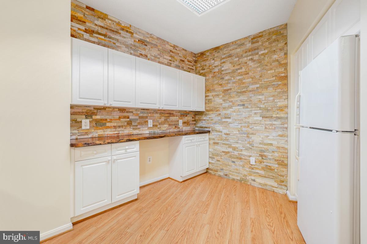 3100 North Leisure World Boulevard, Unit 603 Silver Spring, MD 20906 - Photo 13 of 49 a kitchen with granite countertop white cabinets and white appliances