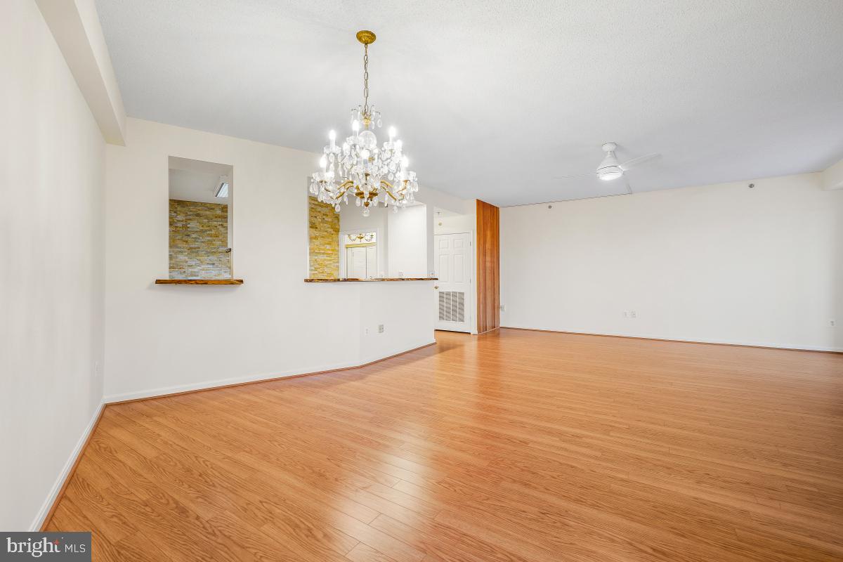 3100 North Leisure World Boulevard, Unit 603 Silver Spring, MD 20906 - Photo 19 of 49 a view of an empty room with chandelier and wooden floor