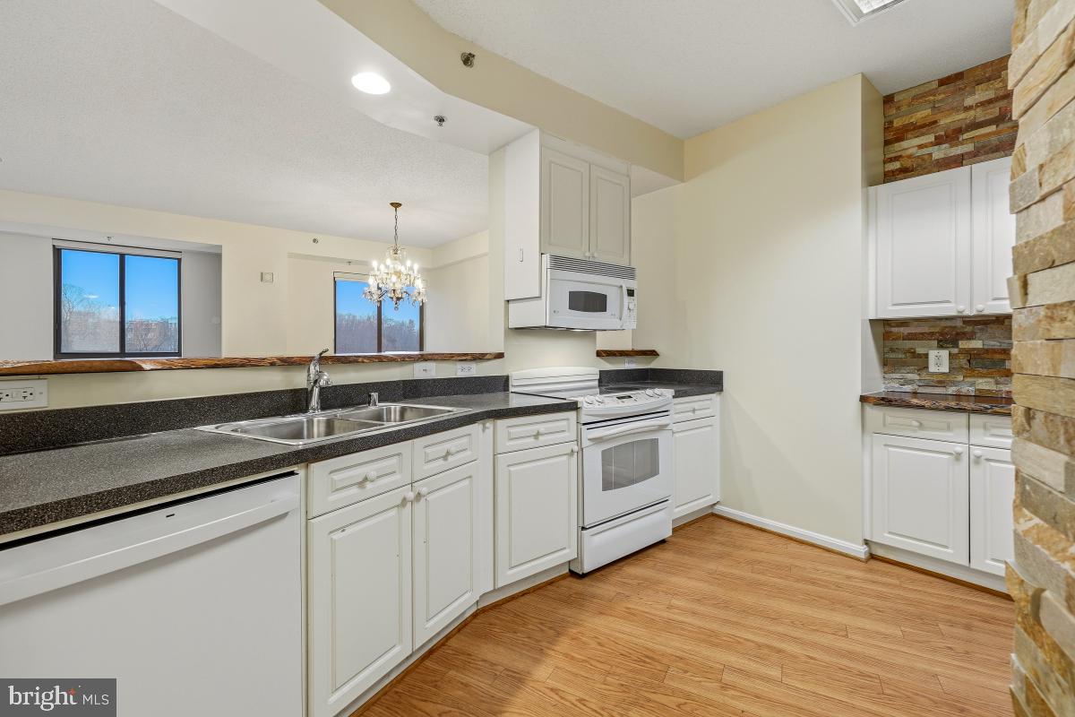 3100 North Leisure World Boulevard, Unit 603 Silver Spring, MD 20906 - Photo 10 of 49 a kitchen with granite countertop white cabinets and white appliances
