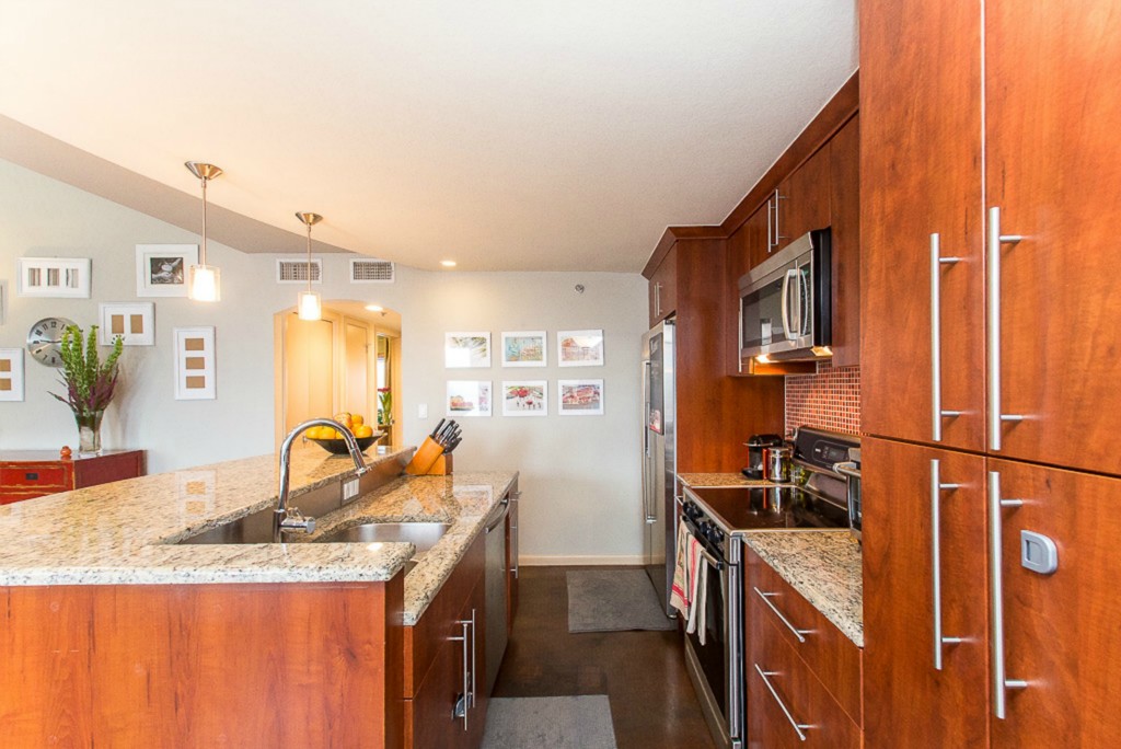 41 Waller Street, Unit 308 Austin, TX 78702 - Photo 13 of 34 a kitchen with granite countertop a sink a stove and refrigerator
