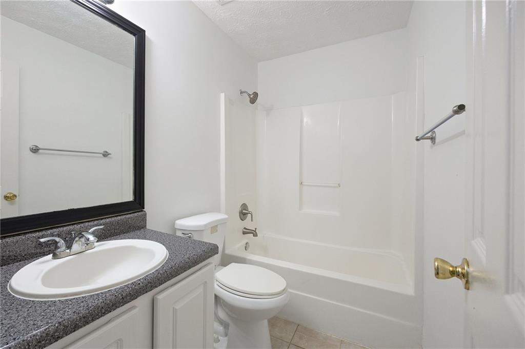 1093 Athena Court Acworth, GA 30101 - Photo 19 of 27 a bathroom with a granite countertop sink toilet and shower