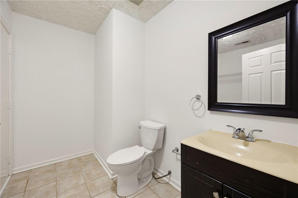 1093 Athena Court Acworth, GA 30101 - Photo 23 of 27 a bathroom with a toilet a sink a mirror and vanity