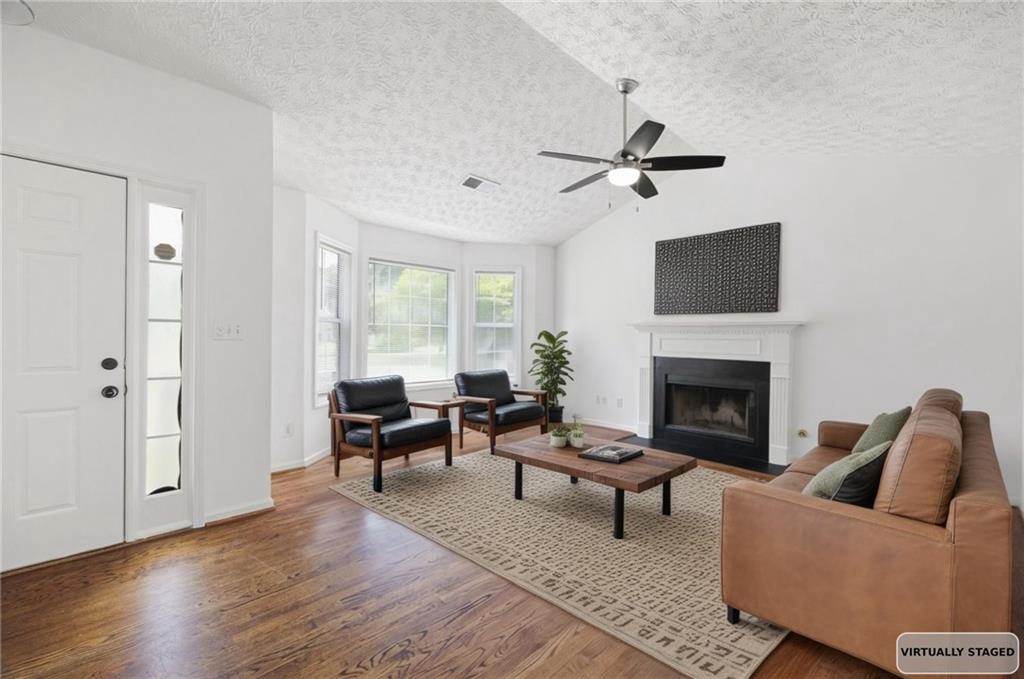 1093 Athena Court Acworth, GA 30101 - Photo 3 of 27 a living room with furniture a fireplace and a flat screen tv