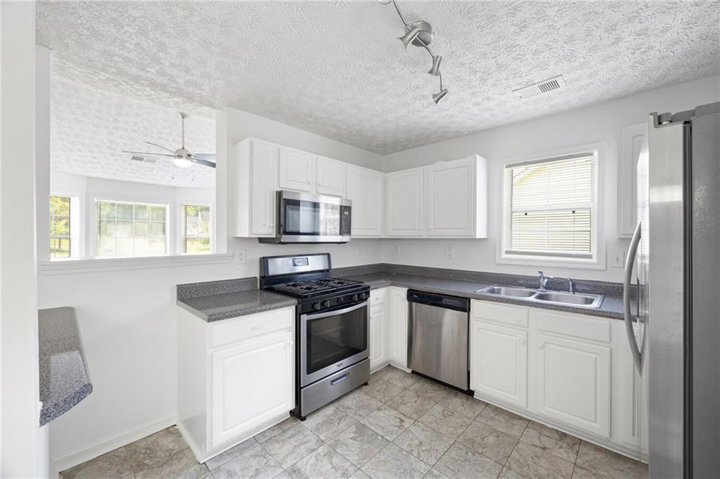 1093 Athena Court Acworth, GA 30101 - Photo 8 of 27 a kitchen with stainless steel appliances granite countertop a sink stove and refrigerator