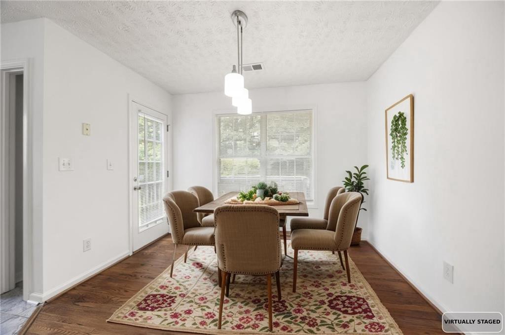 1093 Athena Court Acworth, GA 30101 - Photo 10 of 27 a dining room with furniture a rug and wooden floor