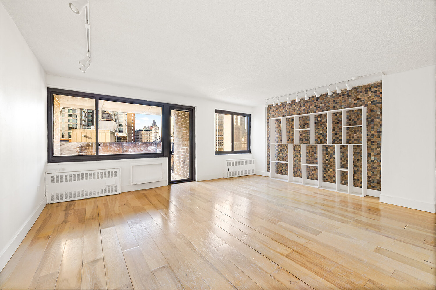 90 Gold Street, Unit 13L Manhattan, NY 10038 - Photo 2 of 10 a view of an empty room with wooden floor and a window