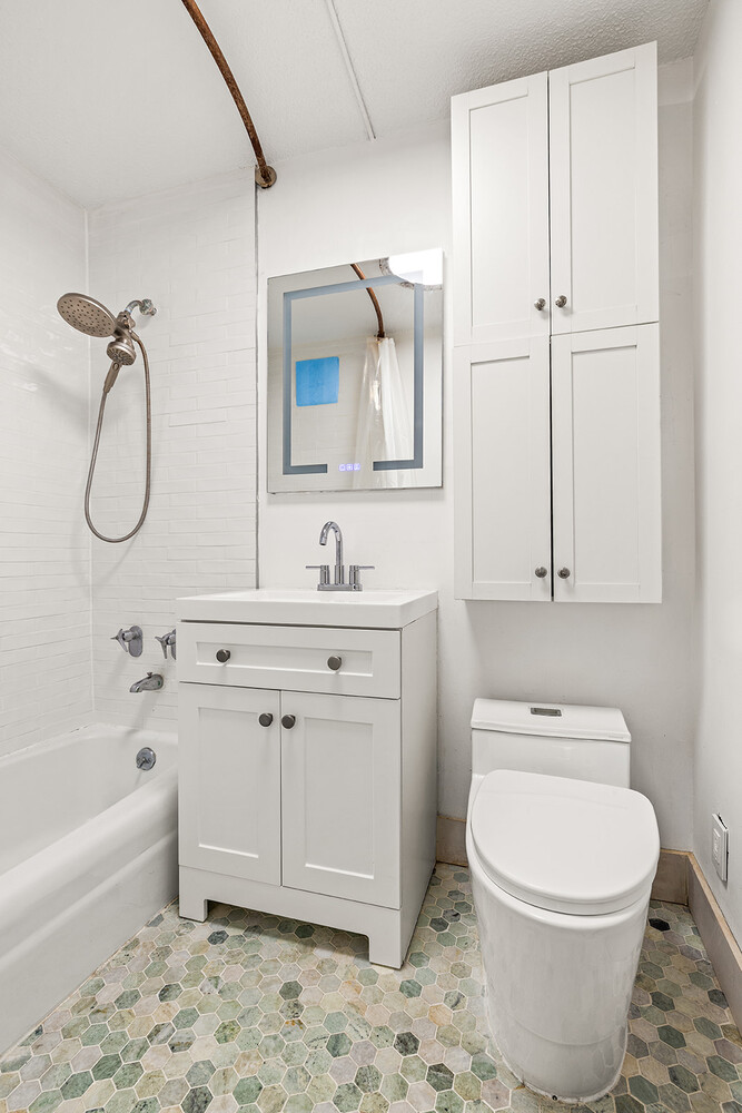 90 Gold Street, Unit 13L Manhattan, NY 10038 - Photo 9 of 10 a bathroom with a sink a toilet and vanity