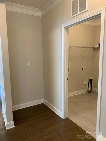 an empty room with wooden floor and cabinet