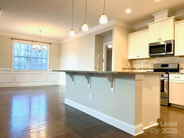 a kitchen with stainless steel appliances granite countertop a sink a stove and a microwave