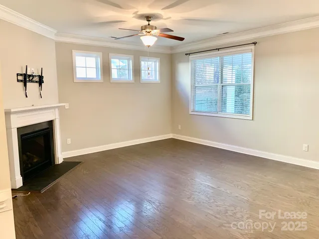 an empty room with windows fireplace and a sink
