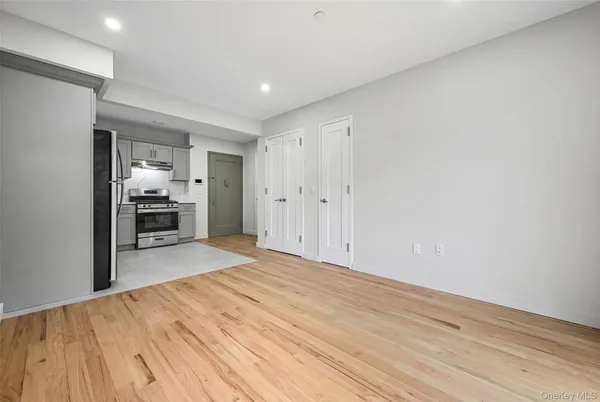 a big room with wooden floor and kitchen view