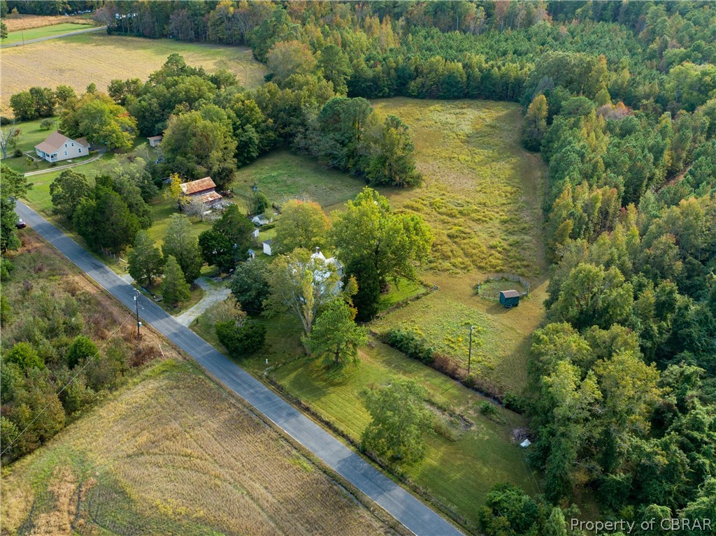 186 Aarons Bch Road Diggs, VA 23045 - Photo 3 of 40 View of cleared property showing barn, stable and lots of mature trees, entire property is wire fenced.