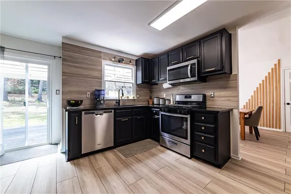 a kitchen with stainless steel appliances granite countertop a sink stove and microwave