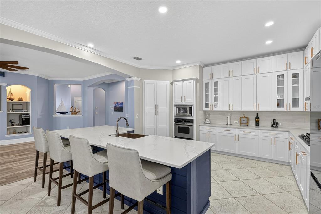 5720 Tortoise Place Apollo Beach, FL 33572 - Photo 10 of 83 a kitchen with stainless steel appliances kitchen island granite countertop a table chairs sink and cabinets