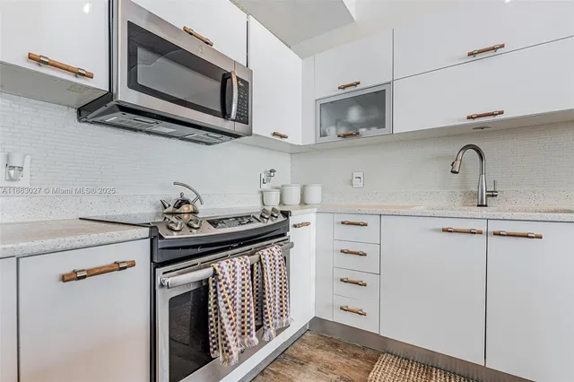 a kitchen with stainless steel appliances granite countertop a sink and a stove