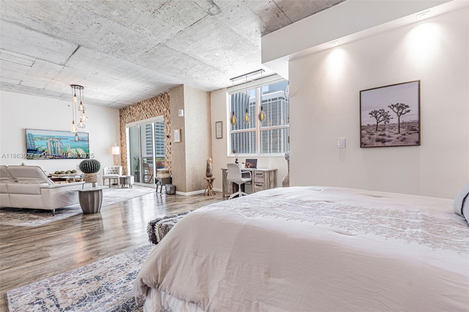 133 Northeast 2nd Avenue, Unit 1208 Miami, FL 33132 - Photo 22 of 33 a spacious bedroom with a large bed and a couch