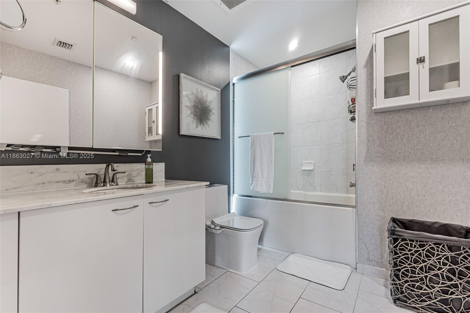 133 Northeast 2nd Avenue, Unit 1208 Miami, FL 33132 - Photo 8 of 33 a bathroom with a granite countertop sink a toilet and a mirror