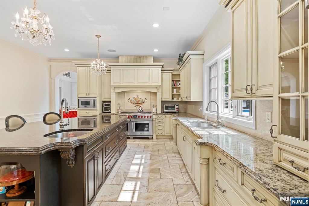 146 East Allendale Road Saddle River, NJ 07458 - Photo 5 of 28 a kitchen with kitchen island granite countertop a sink appliances cabinets and a counter top space