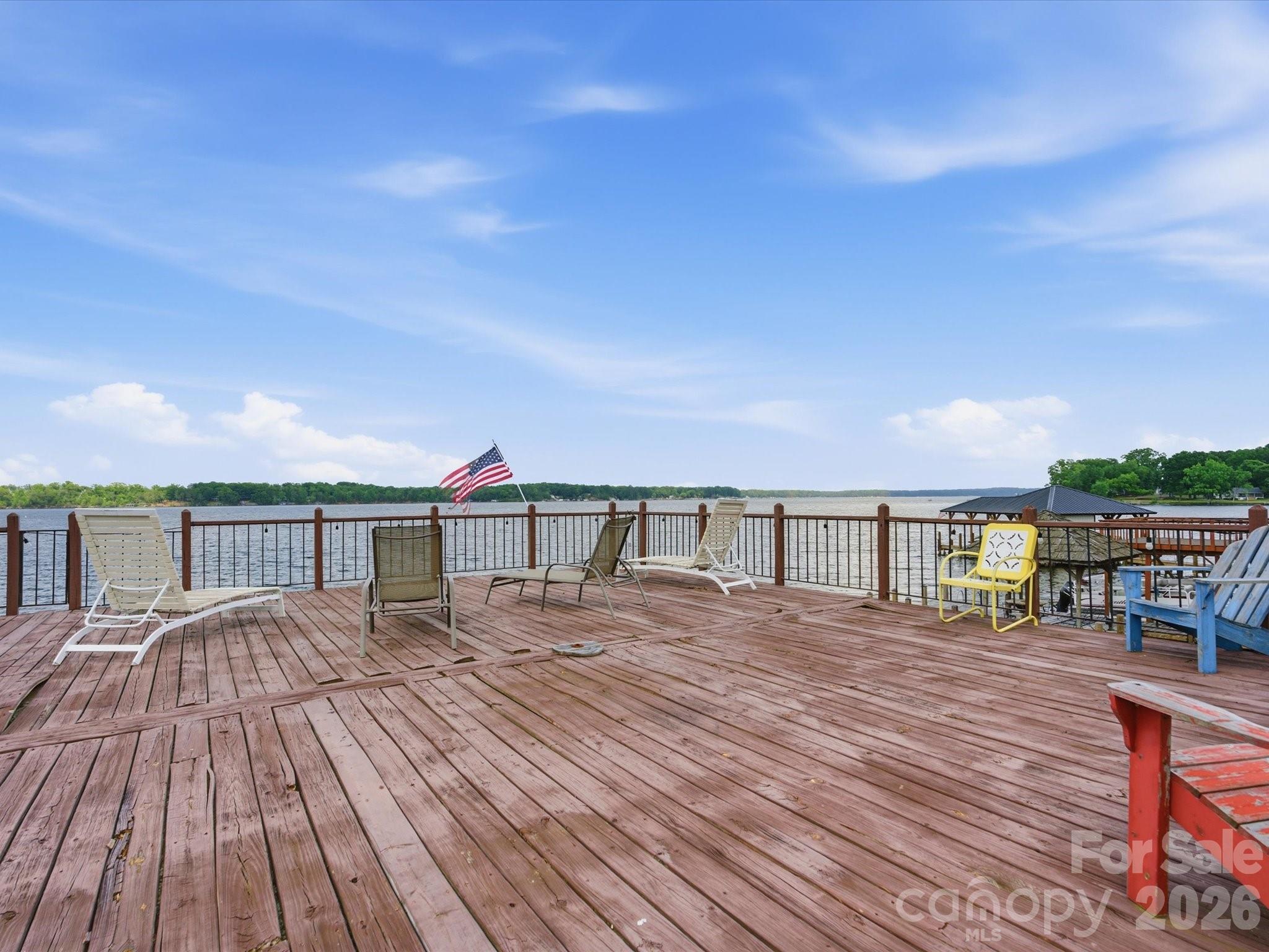 562 Lake Head Road Norwood, NC 28128 - Photo 38 of 43 a view of a roof deck with table and chairs a barbeque with wooden floor and fence