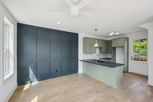 a kitchen with kitchen island a sink stainless steel appliances and cabinets