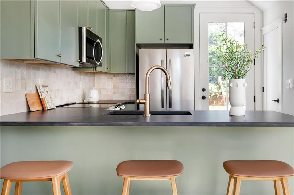 1160 Boulevard Southeast, Unit 11 Atlanta, GA 30312 - Photo 6 of 32 a kitchen with stainless steel appliances a microwave a stove and cabinets
