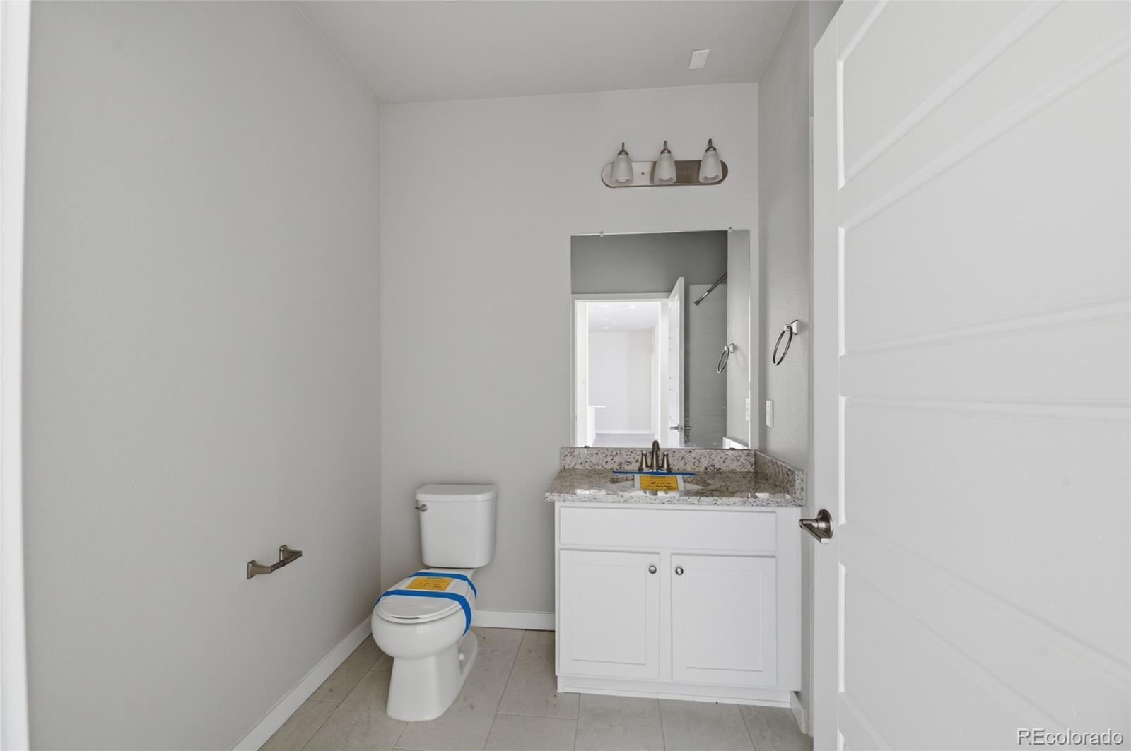 9291 Twenty Mile Road, Unit 207 Parker, CO 80134 - Photo 12 of 25 a bathroom with a toilet sink and mirror