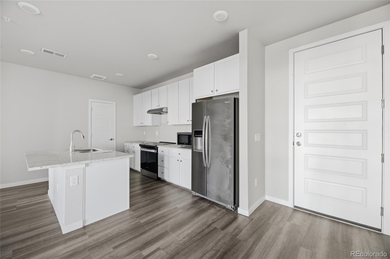 9291 Twenty Mile Road, Unit 207 Parker, CO 80134 - Photo 3 of 25 a kitchen with a refrigerator sink and cabinets