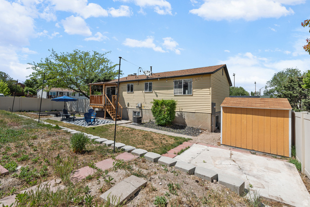 3951 Brixton Road Salt Lake City, UT 84129 - Photo 22 of 22 Expansive backyard featuring a wood deck with stairs, a patio area, and a separate storage shed