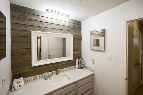 a bathroom with a sink vanity and mirror