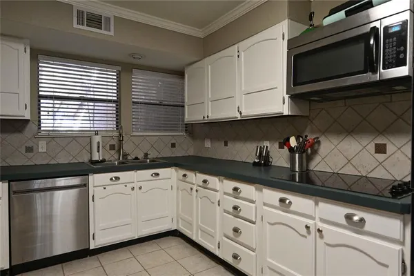 a kitchen with granite countertop white cabinets stainless steel appliances and sink