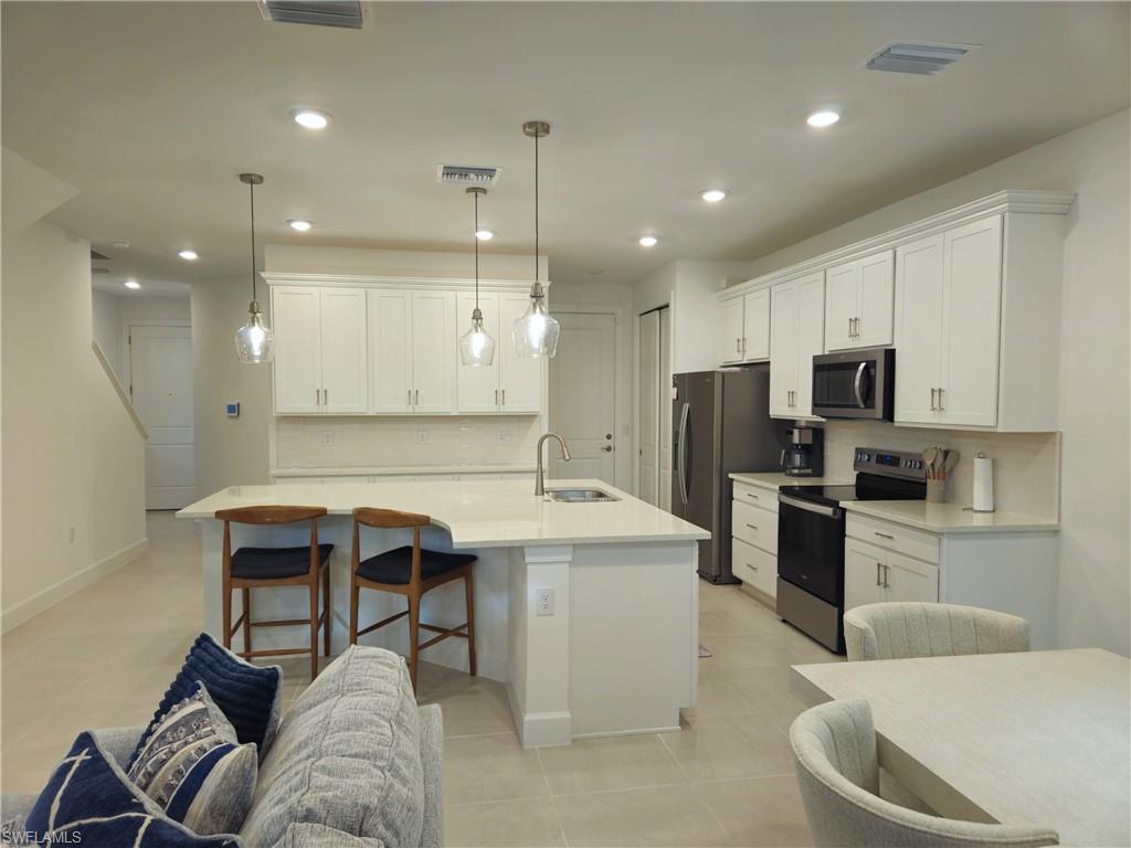 Undisclosed Address Naples, FL 34119 - Photo 12 of 50 a kitchen with a sink stainless steel appliances and cabinets