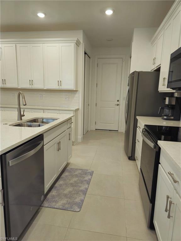 Undisclosed Address Naples, FL 34119 - Photo 8 of 50 a kitchen with stainless steel appliances a sink stove refrigerator and cabinets