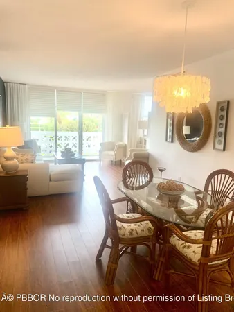 a view of a dining room and livingroom with furniture wooden floor and a rug