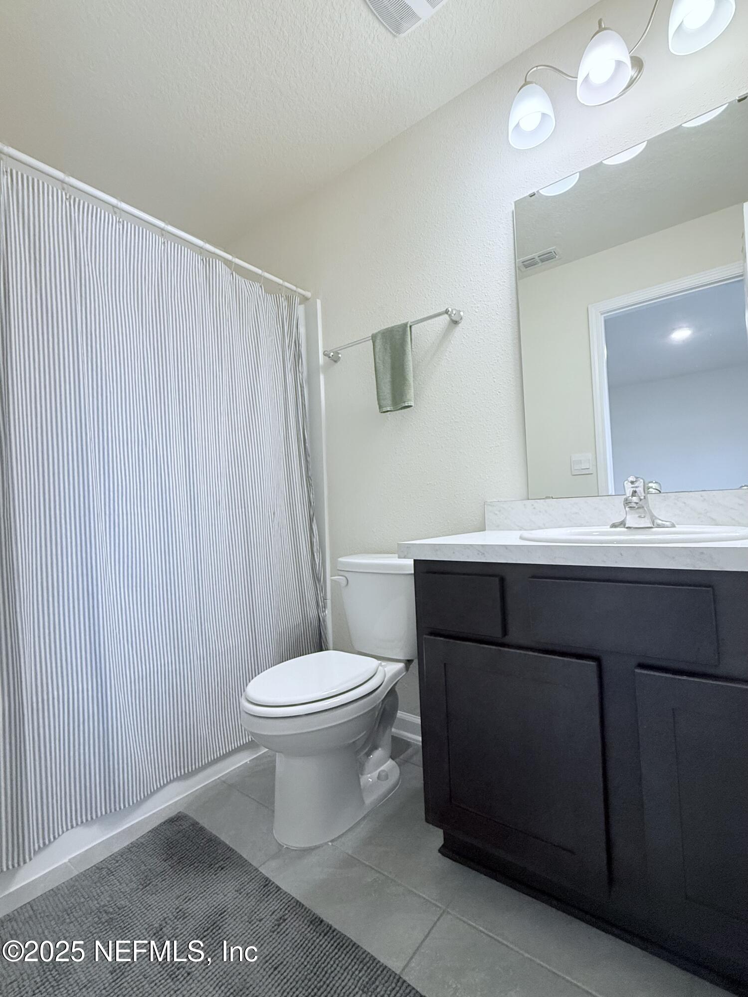 48 Java Lane St. Augustine, FL 32092 - Photo 12 of 26 a bathroom with a sink a toilet a mirror and shower curtain
