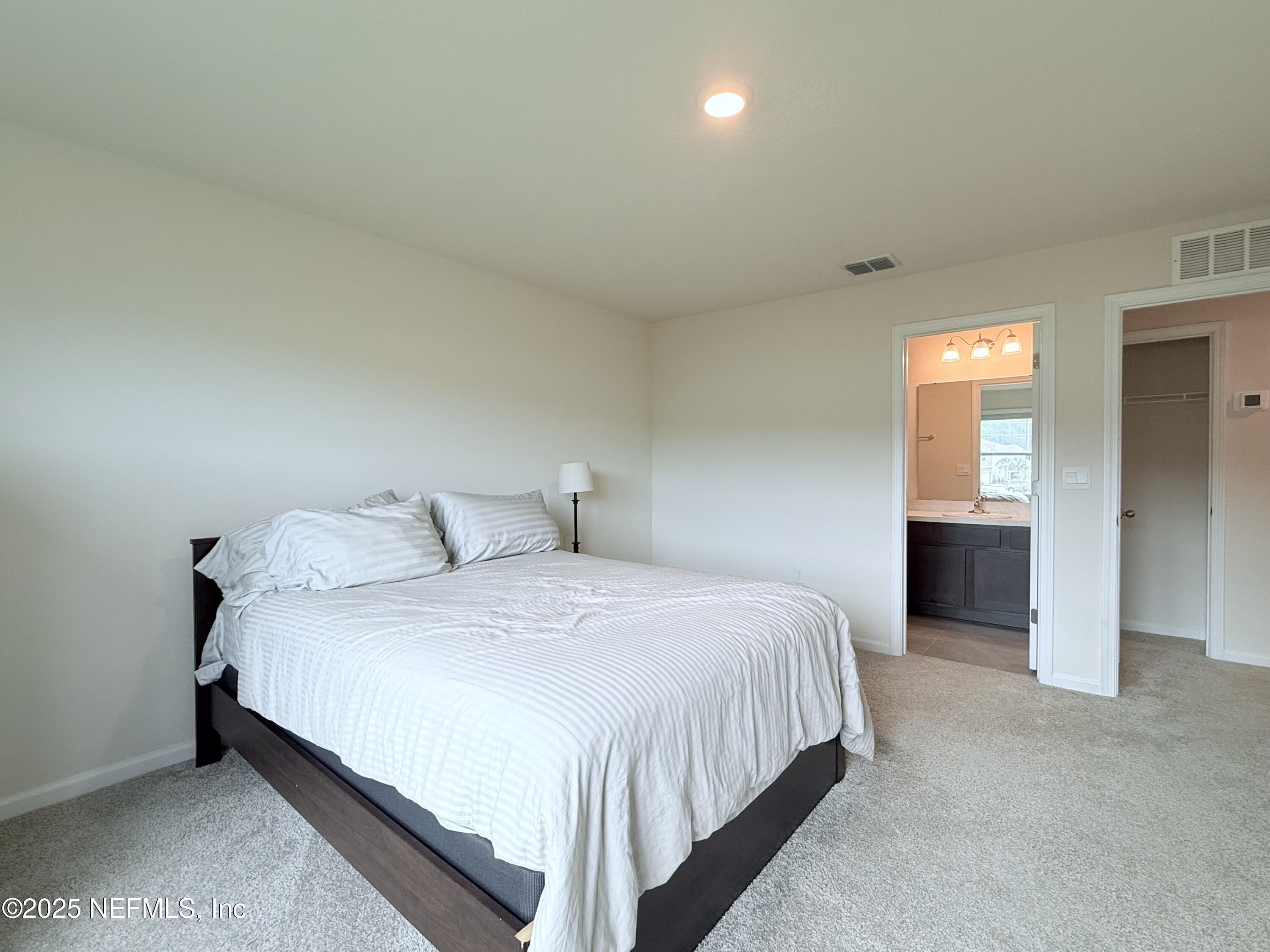 48 Java Lane St. Augustine, FL 32092 - Photo 14 of 26 a spacious bedroom with a bed and a lamp