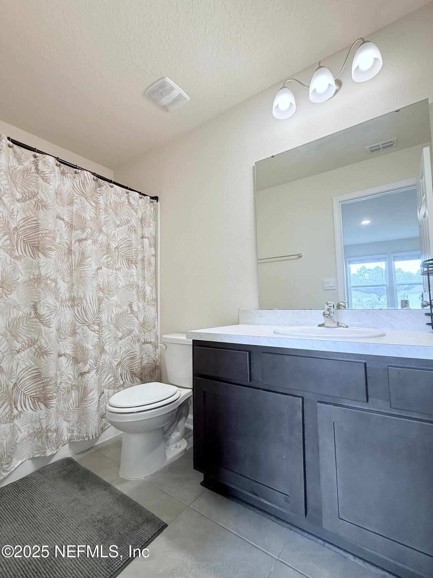 48 Java Lane St. Augustine, FL 32092 - Photo 17 of 26 a bathroom with a sink a toilet a mirror and a shower