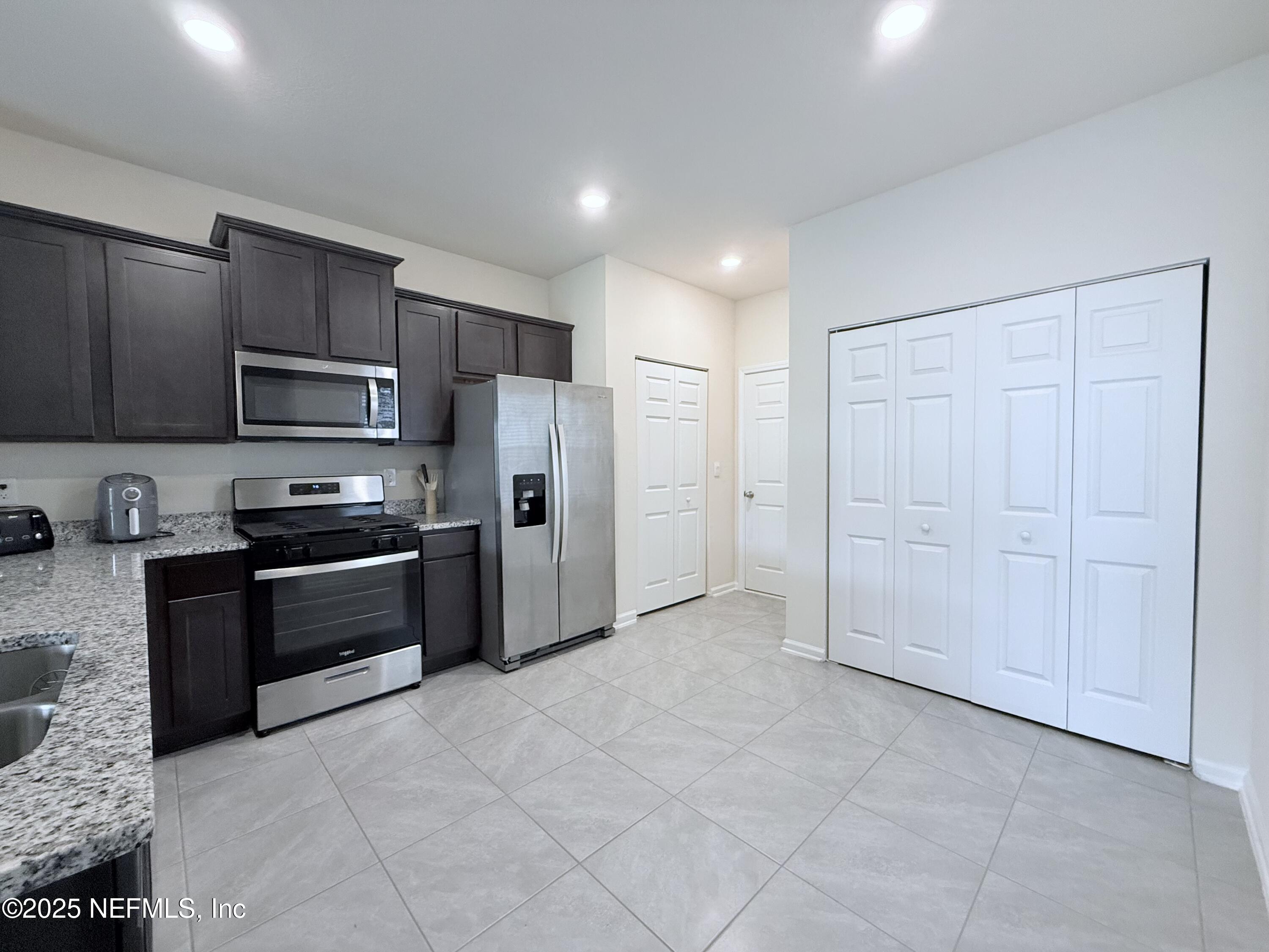 48 Java Lane St. Augustine, FL 32092 - Photo 2 of 26 a kitchen with granite countertop a refrigerator and a stove top oven