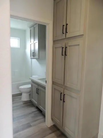 a bathroom with a granite countertop sink toilet and shower